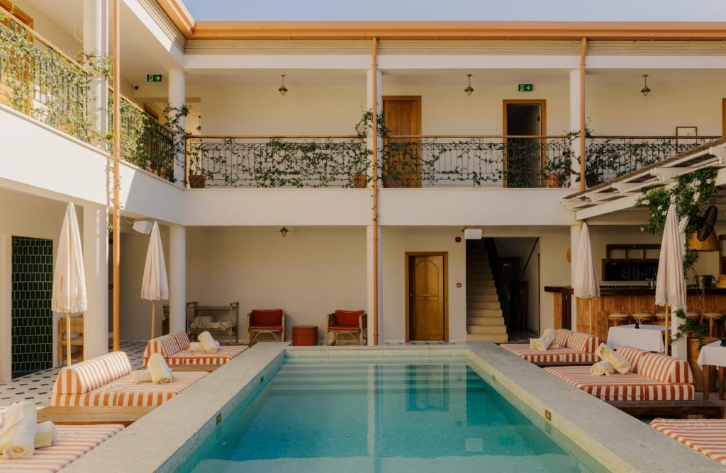 Courtyard pool framed by striped loungers at Agora Hotel